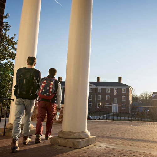 Students walking through the pillars on campus